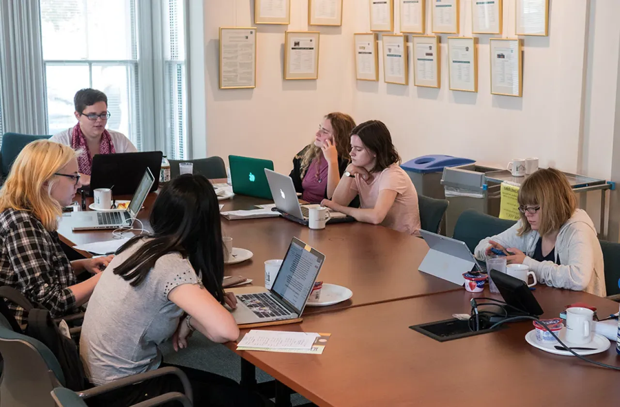 Students gathered around a table in the Kahn colloquium room